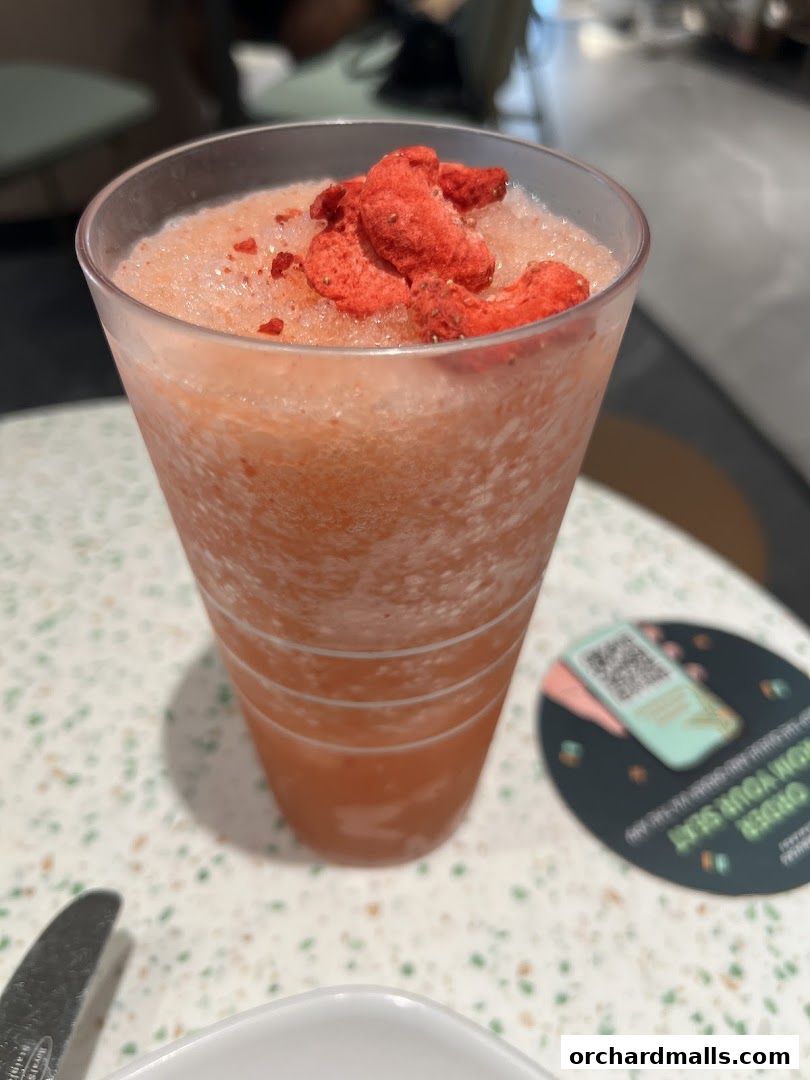 A close-up of a refreshing strawberry-flavored frozen drink topped with freeze-dried strawberries.