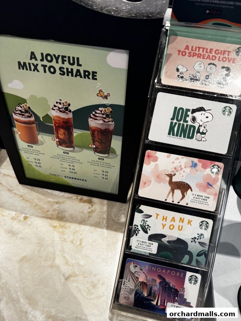 Starbucks display featuring Snoopy-themed drinks and various gift cards.