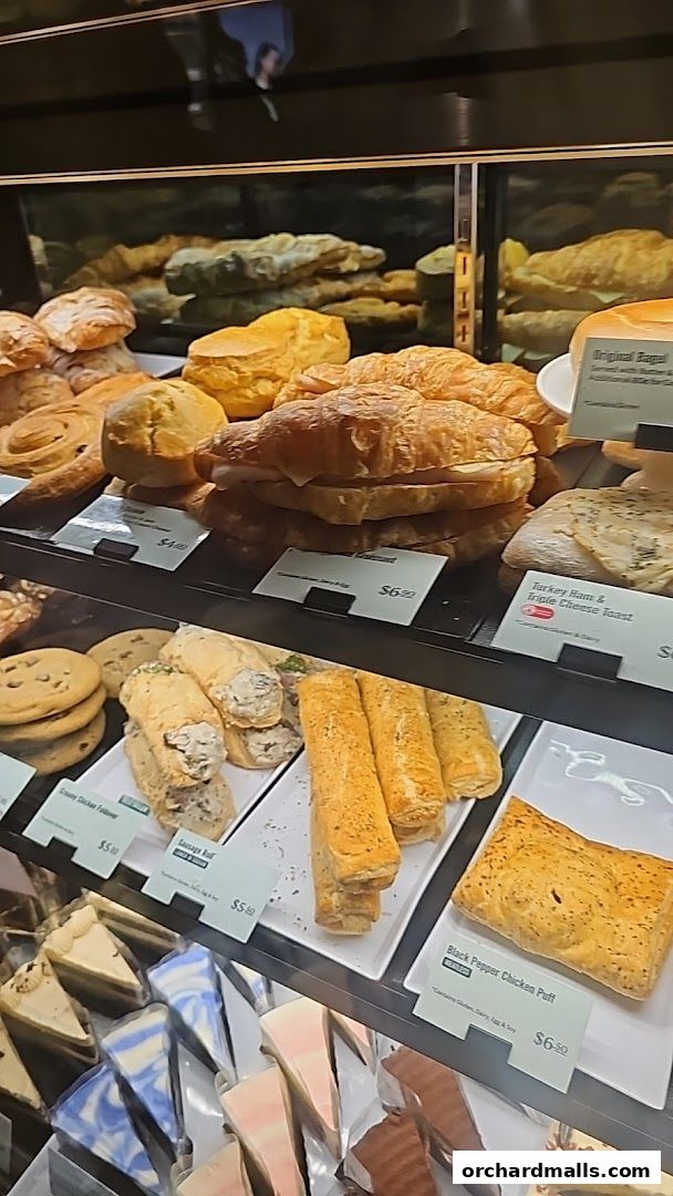 A display case filled with various pastries, sandwiches, and cakes at Starbucks.