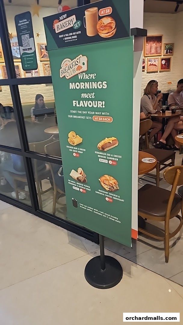 A promotional sign for Starbucks Breakfast Club featuring various breakfast sets and drinks.