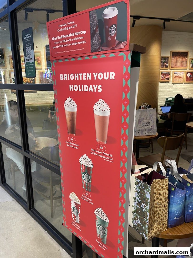 Starbucks promotes holiday drinks and a reusable cup offer with festive signage.