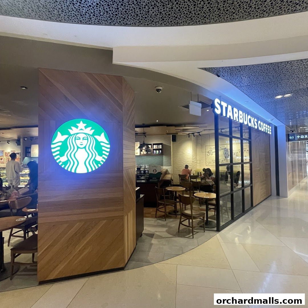 The exterior of a Starbucks coffee shop with its iconic logo and seating area visible.