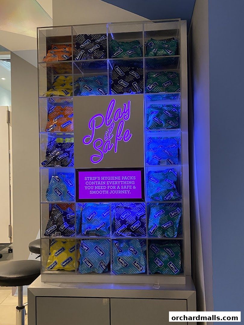A display case filled with hygiene packs and a neon sign that says 'Play it Safe'.
