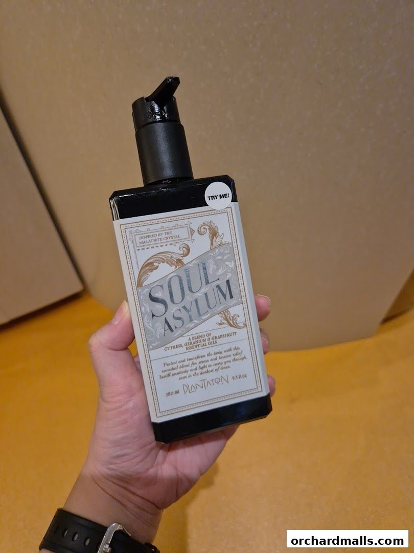 A hand holds a bottle of 'Soul Asylum' essential oil blend.