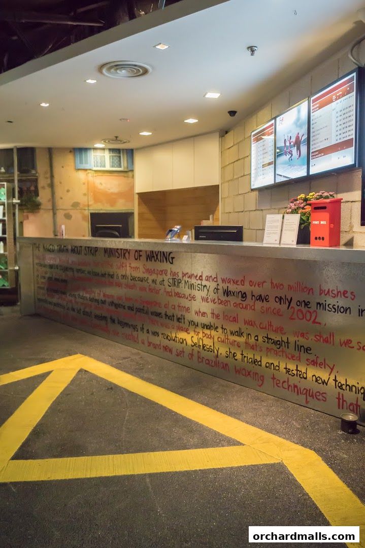 The reception counter of Strip Co-Ed Wheelock with a motivational quote and digital displays.