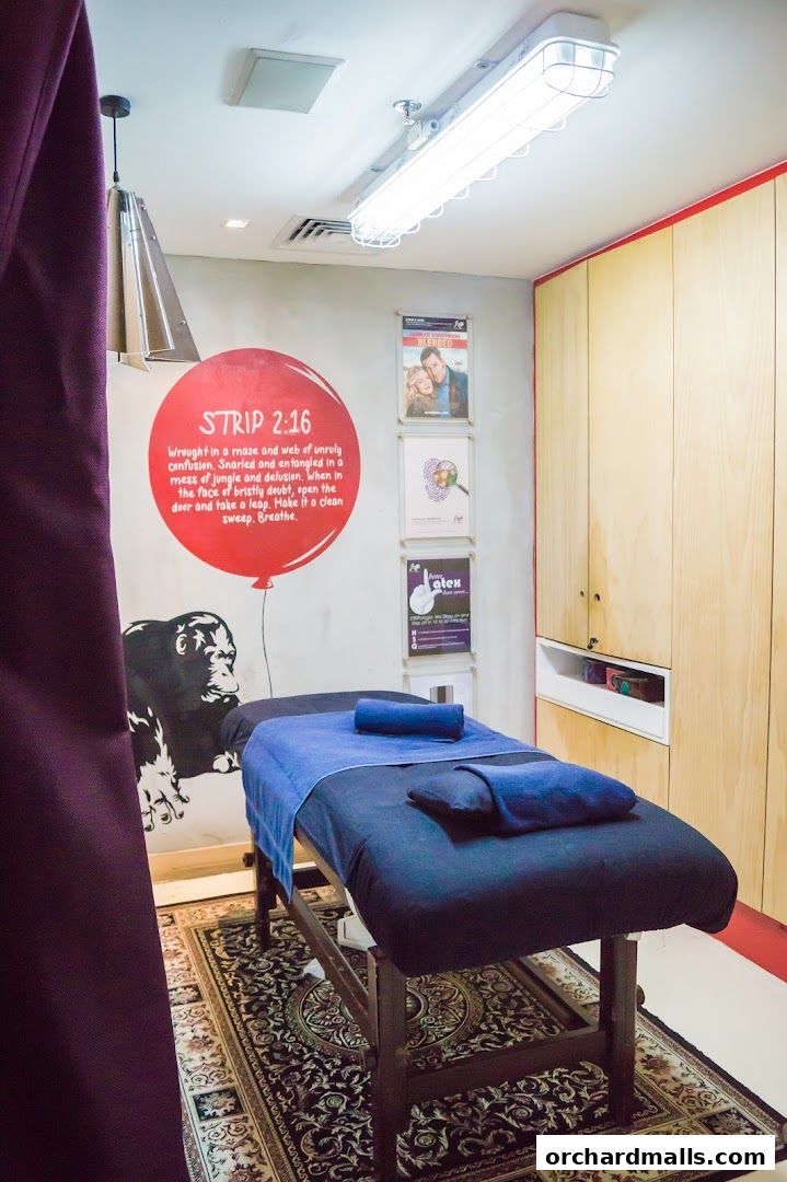 A massage table is set up in a room with a gorilla mural and inspirational text on the wall.