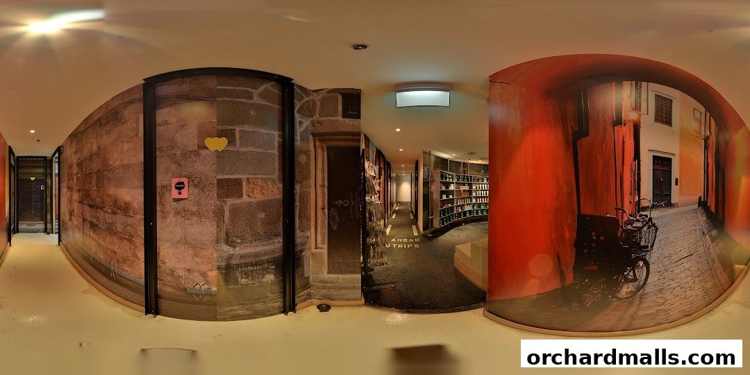 Interior view of a shop with stone walls, a hallway, and shelves stocked with products.