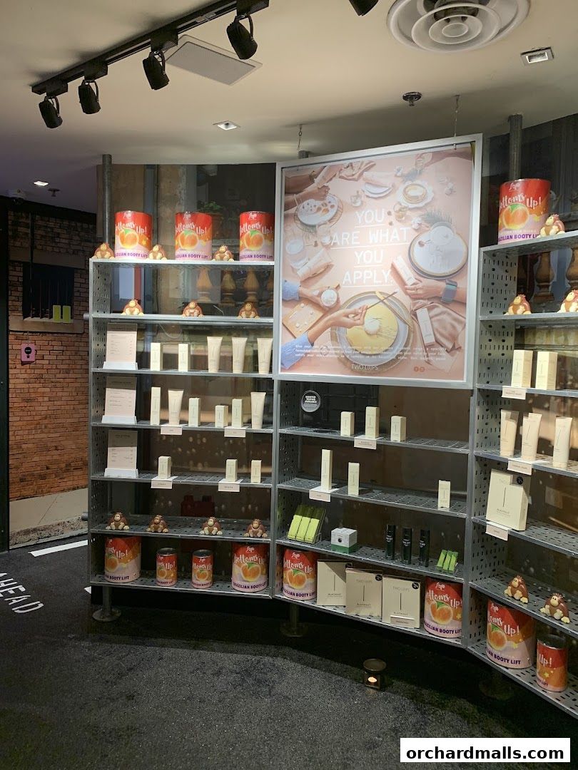 Shelves stocked with skincare products and branded cans, with a large marketing poster.