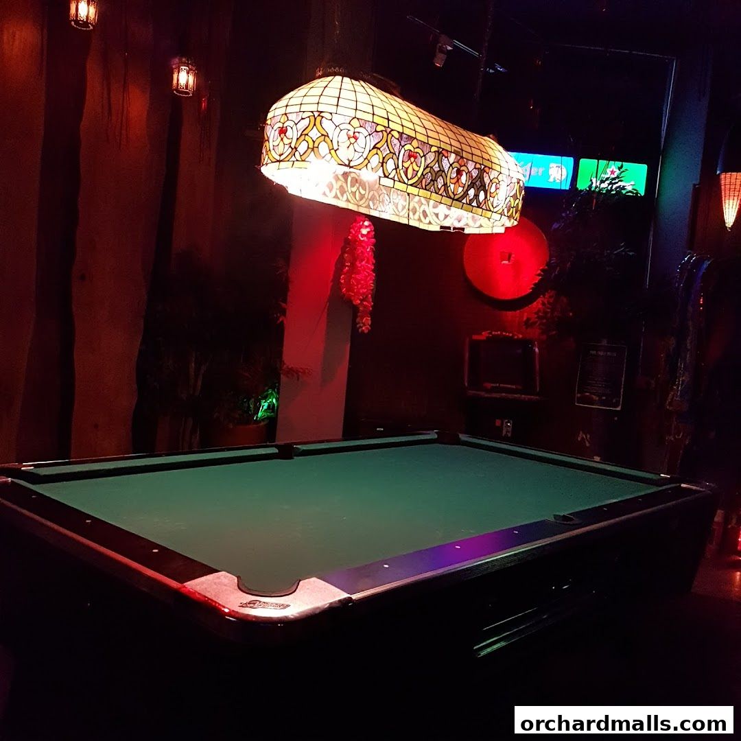 A dimly lit room with a pool table and decorative lighting.