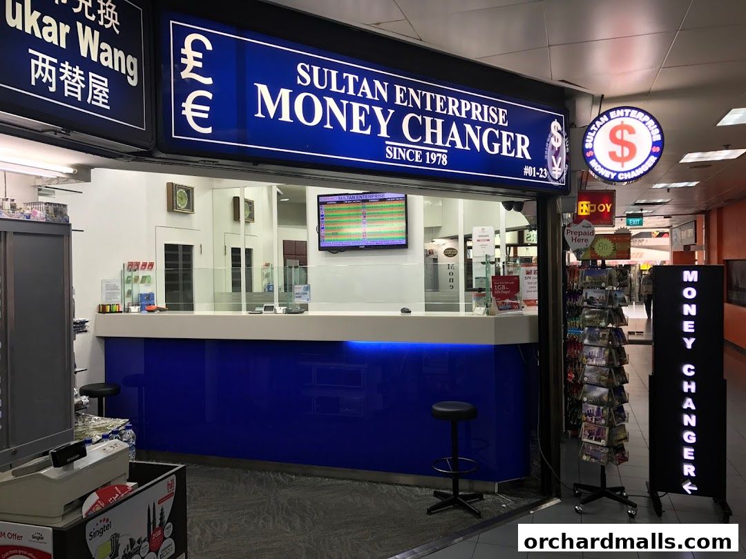 Sultan Enterprise Money Changer shop front with currency symbols and a digital display.