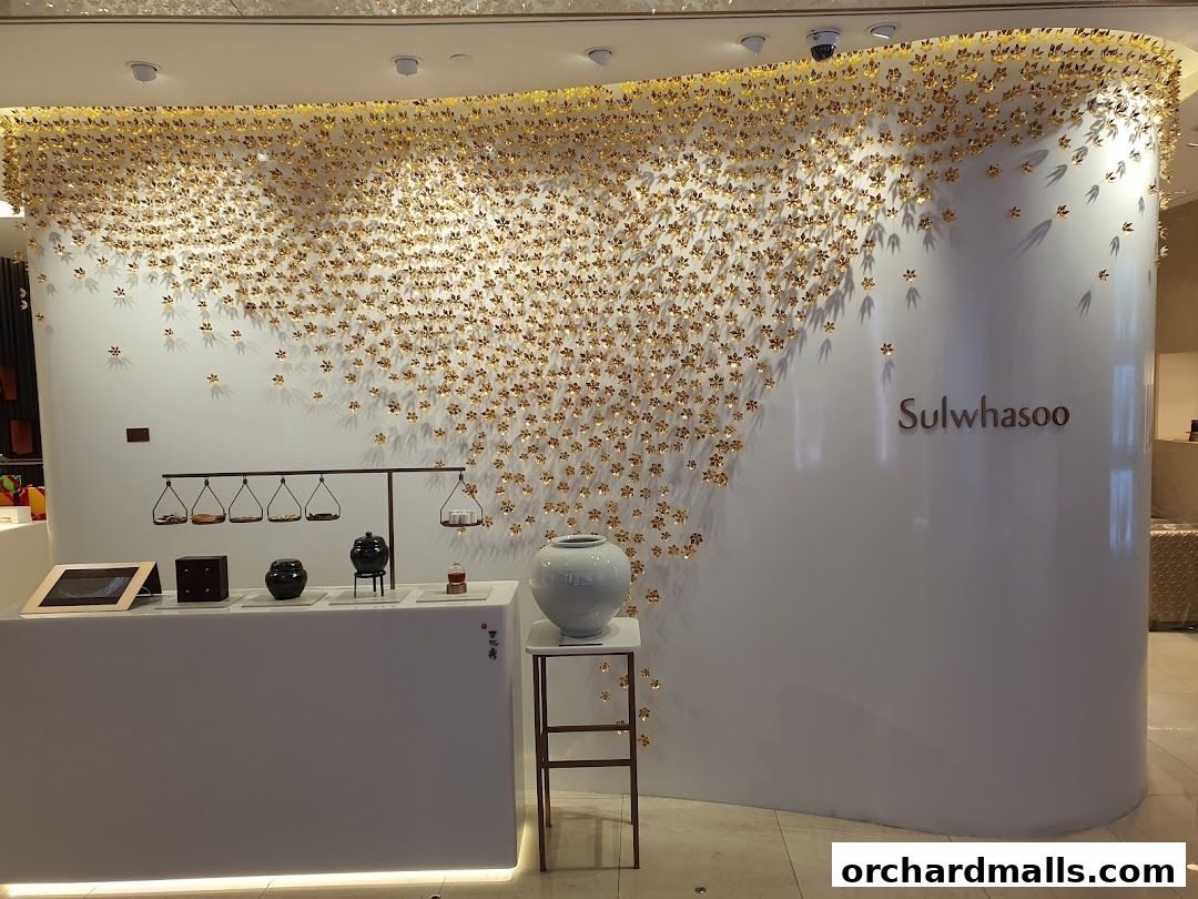 Sulwhasoo boutique interior with a striking gold floral wall art and product displays.