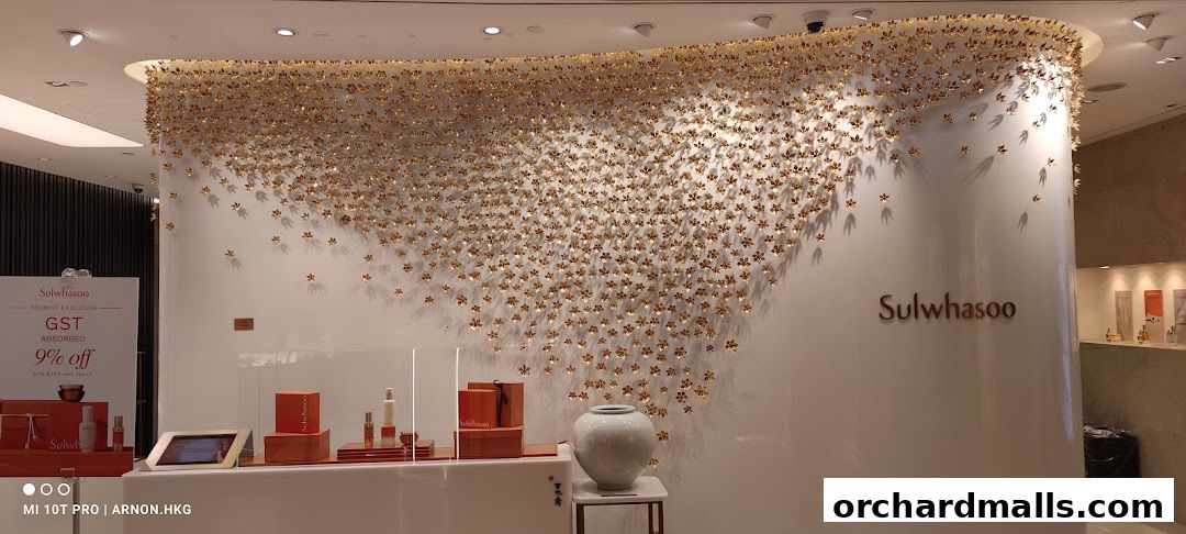 Sulwhasoo boutique interior with a striking gold floral wall art and product displays.