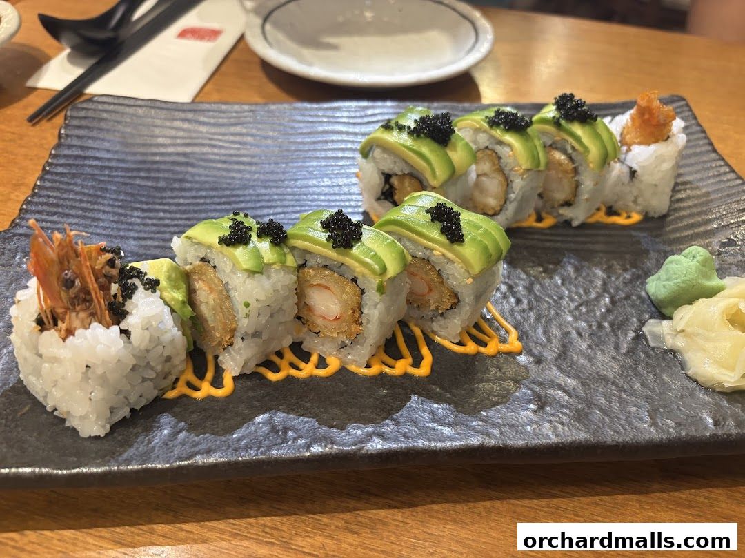 A close-up of a sushi platter featuring avocado rolls with shrimp and black caviar.
