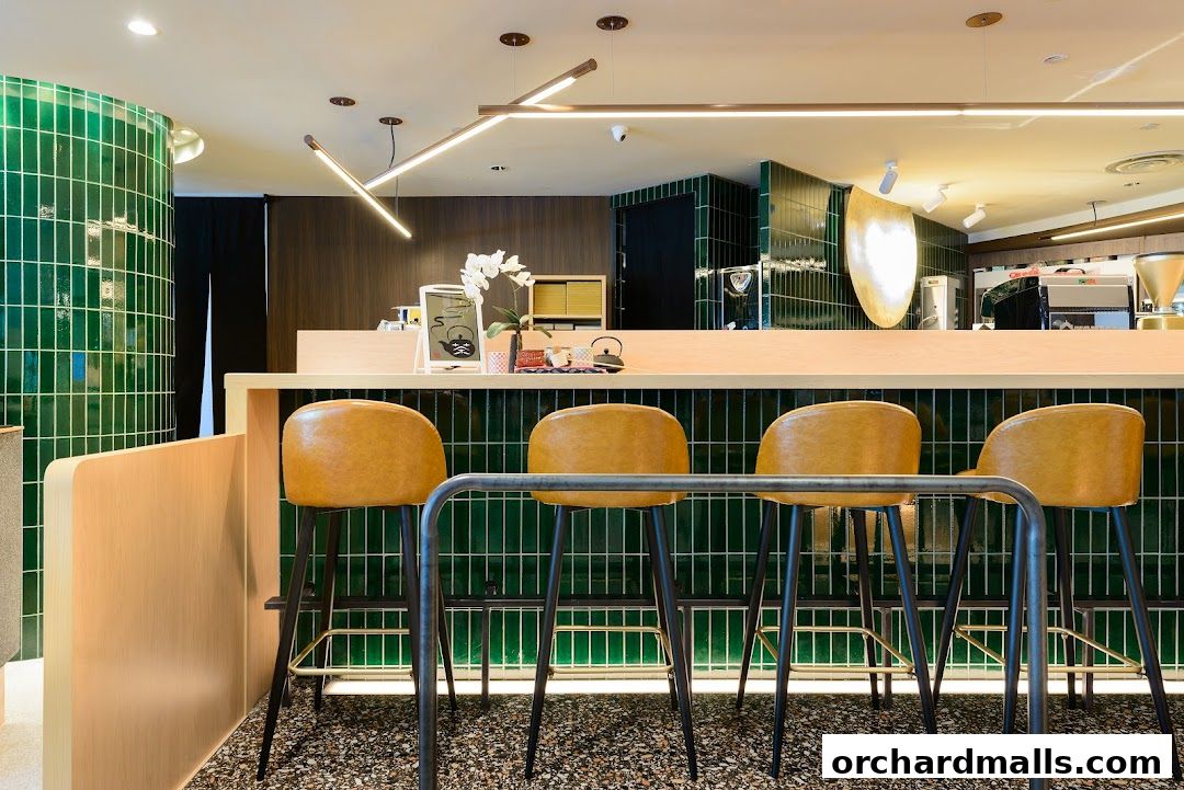 Interior of a modern Japanese dining cafe with green tiled walls and bar stools.