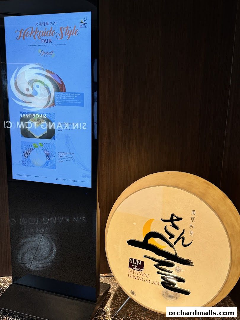 A digital menu board displays Hokkaido Style Fair desserts and a circular sign for SUN with MOON Japanese Dining & Cafe.