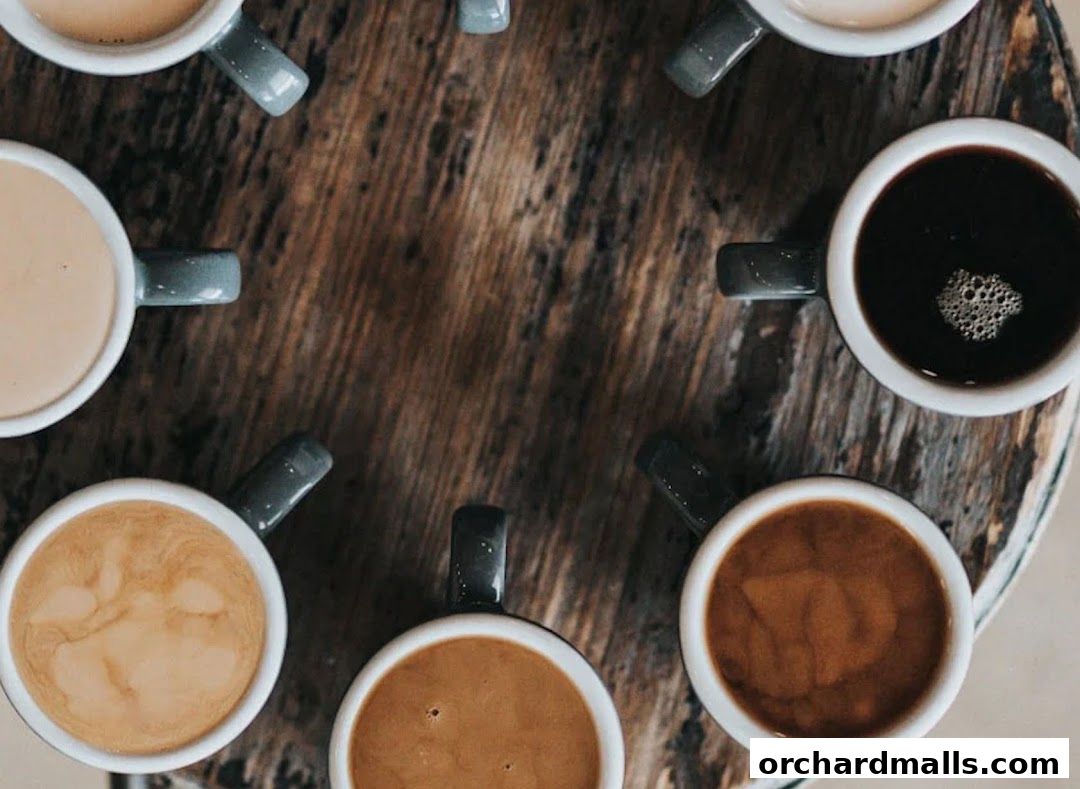 A top-down view of several cups of coffee arranged in a circle on a wooden table.