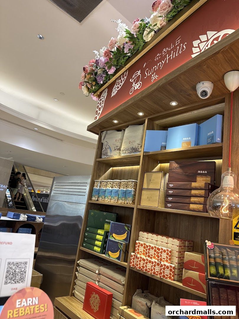 Shelves stocked with various food products, including chocolates and snacks, at SunnyHills Orchard.