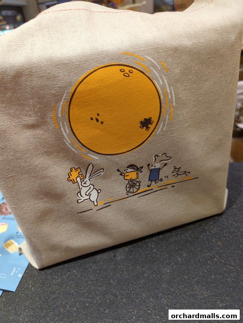 A canvas tote bag with a whimsical illustration of a rabbit and other characters.