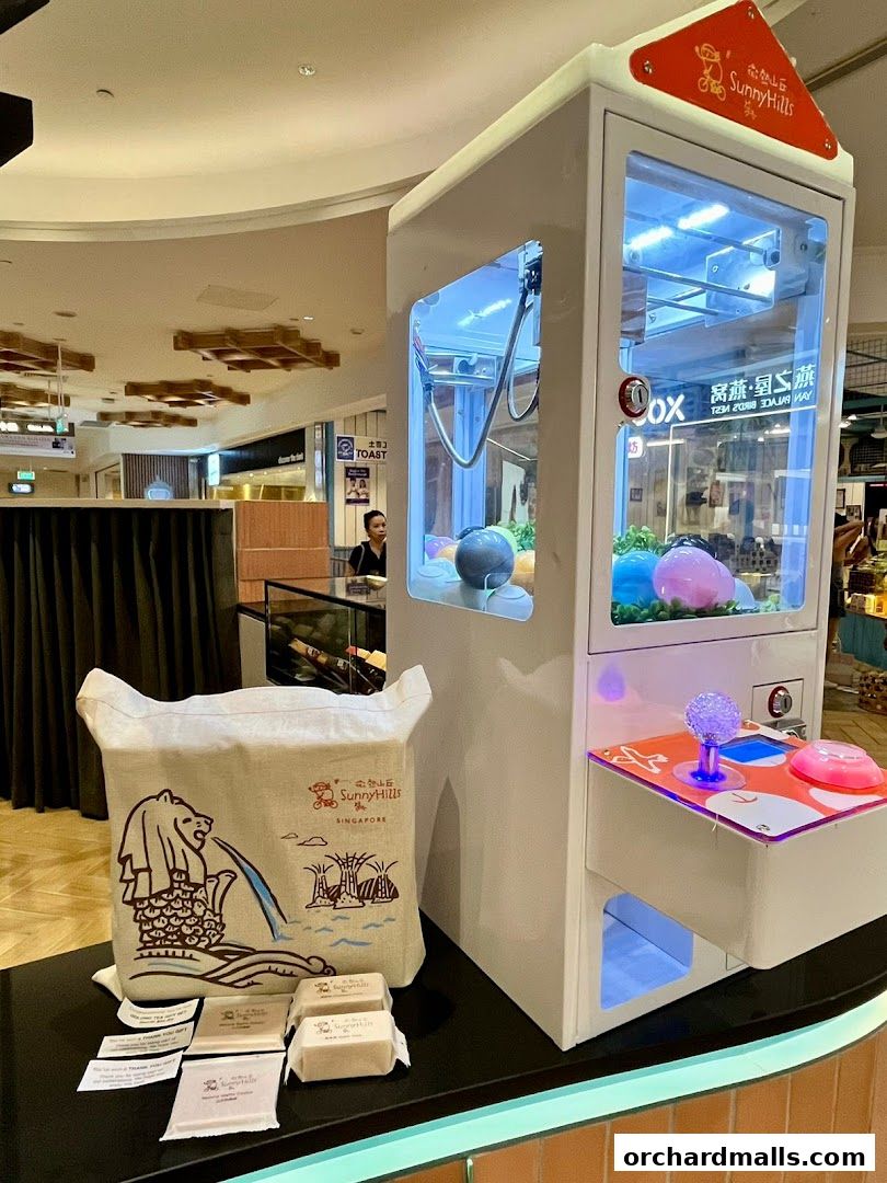 SunnyHills Orchard shop display featuring a claw machine and branded merchandise.
