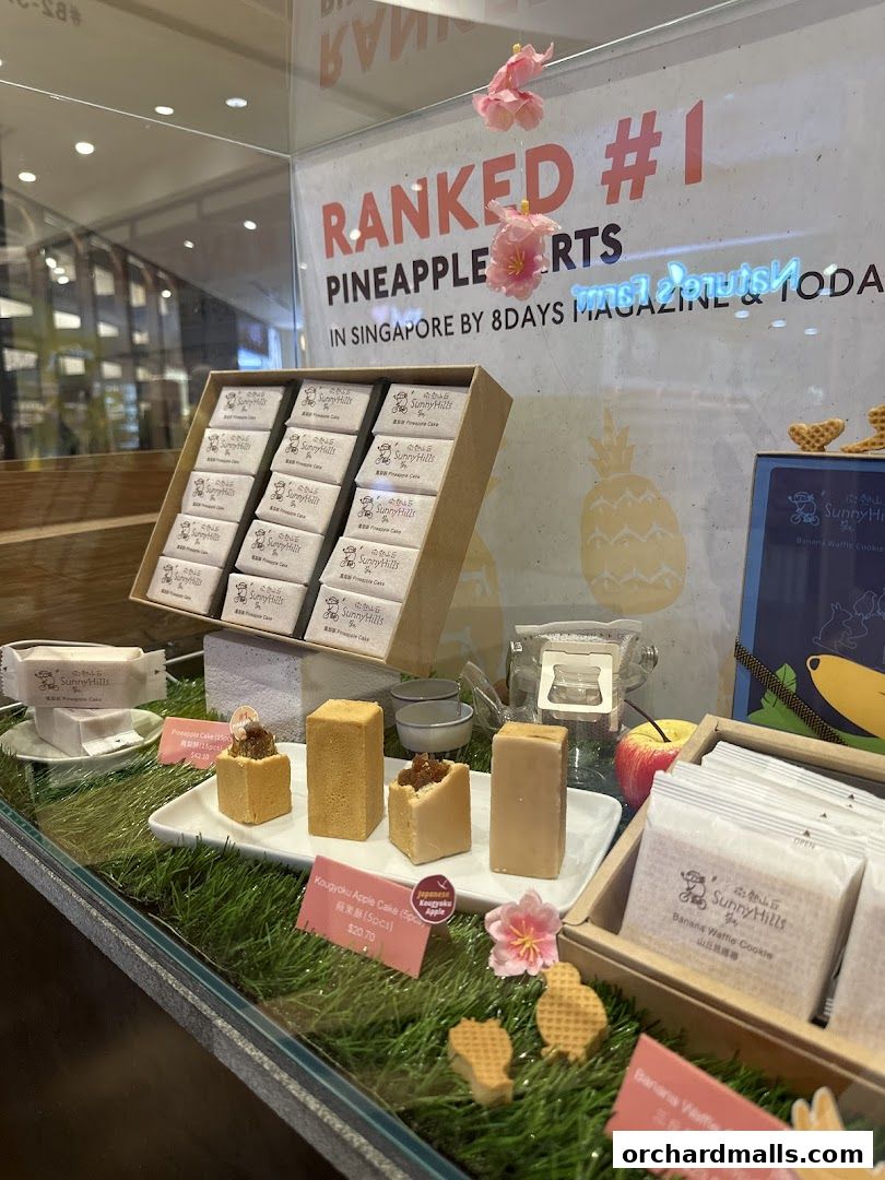 Display of SunnyHills pineapple tarts and apple cakes, ranked #1 in Singapore.