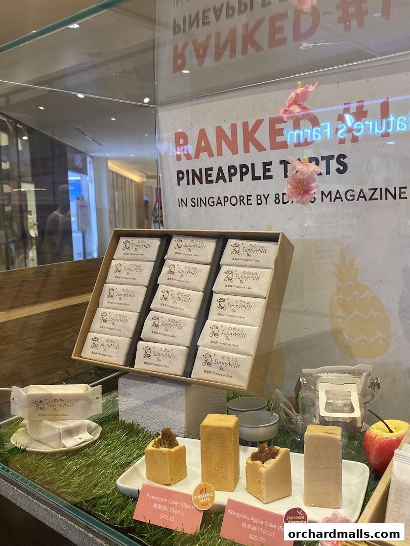 Display of SunnyHills pineapple tarts and apple cakes, ranked #1 in Singapore.