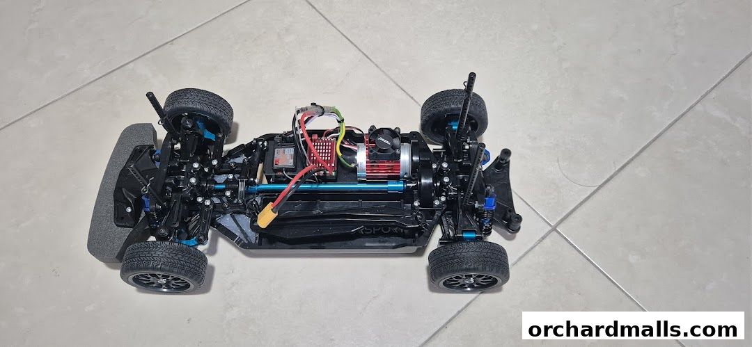A detailed view of a high-performance remote-controlled car chassis with visible electronics.