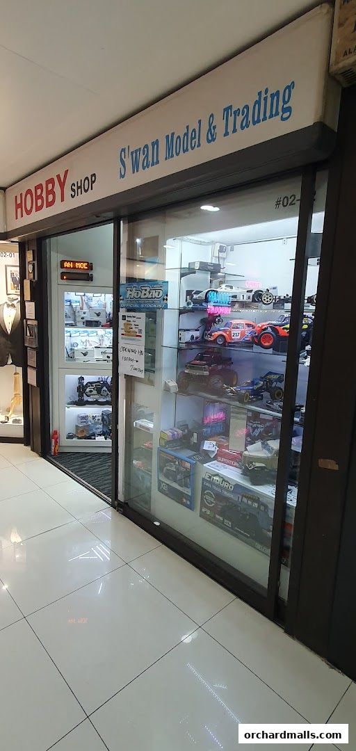 Exterior of Swan Model & Trading hobby shop showcasing model cars and accessories in display cases.