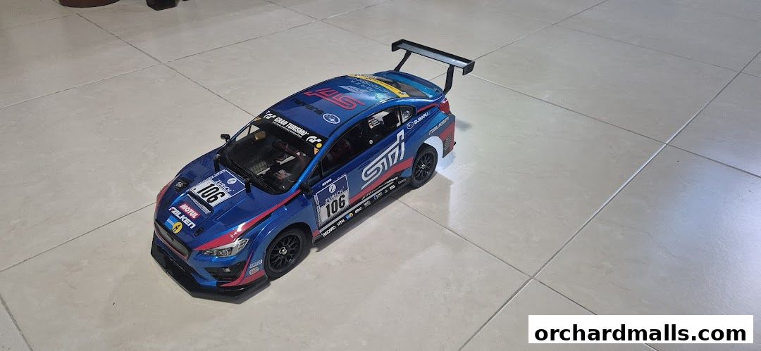 A detailed model of a blue Subaru WRX STI race car with sponsor decals.