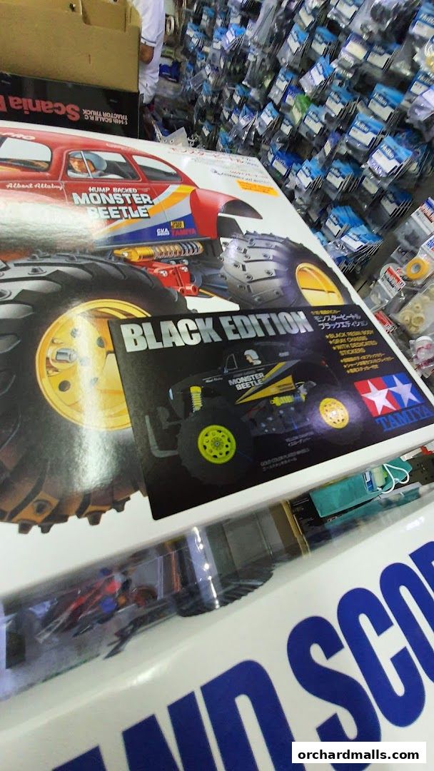 A display of Tamiya model car kits, including the Monster Beetle Black Edition.