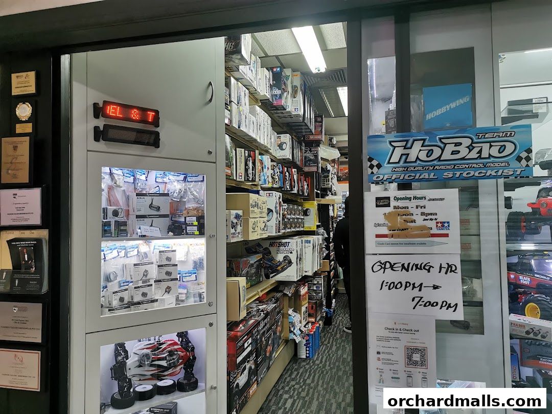 Shop front displaying radio control models and accessories, with opening hours posted.