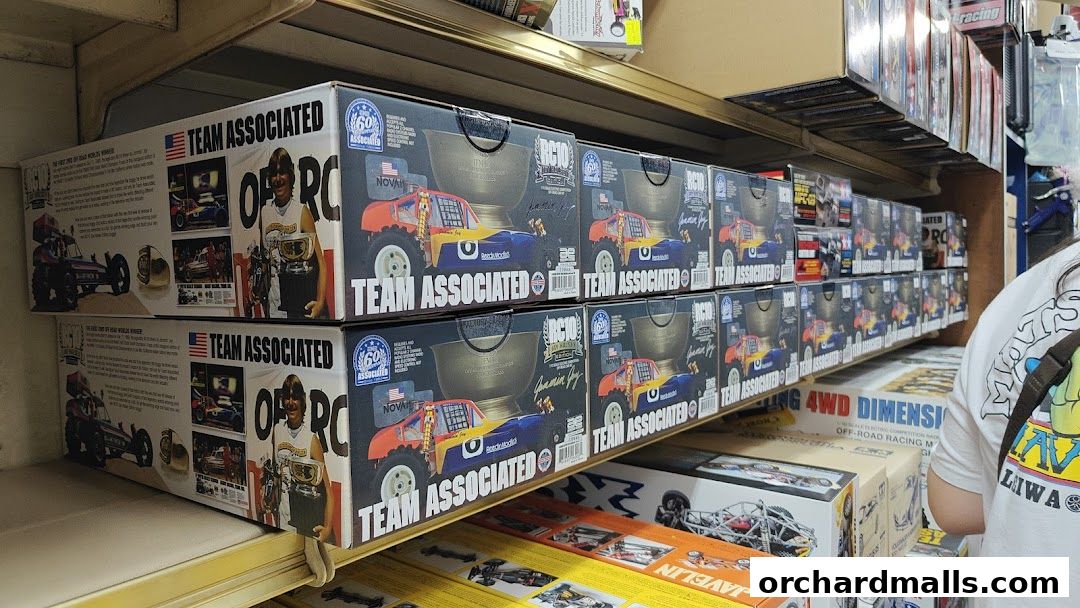 Shelves stocked with boxes of Team Associated RC cars and related racing products.