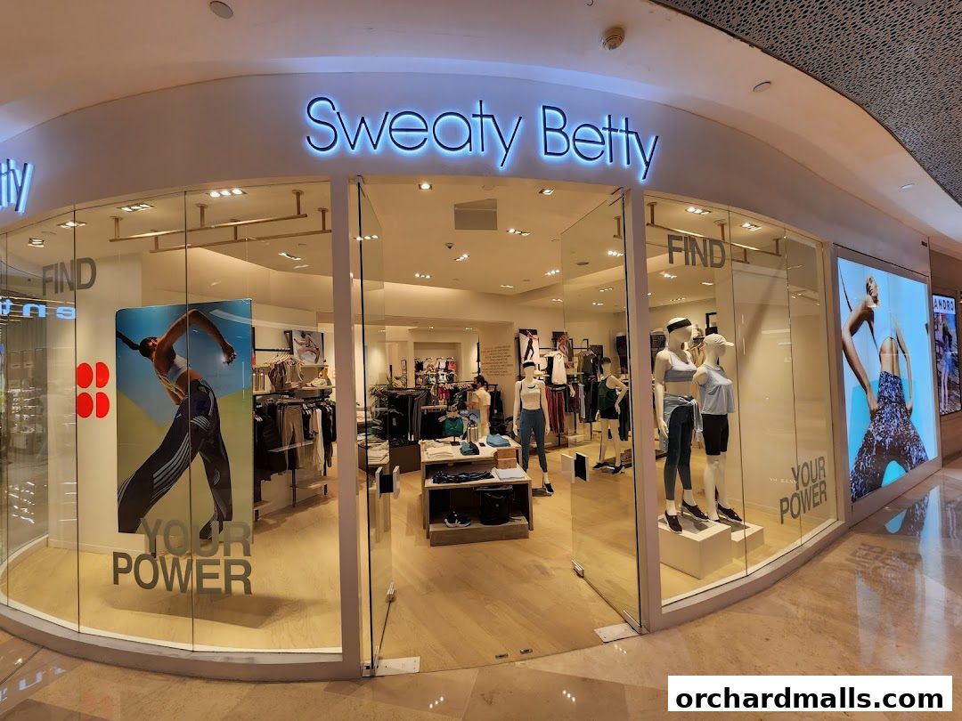 The Sweaty Betty shop front displays activewear on mannequins and racks, with inspirational campaign imagery.