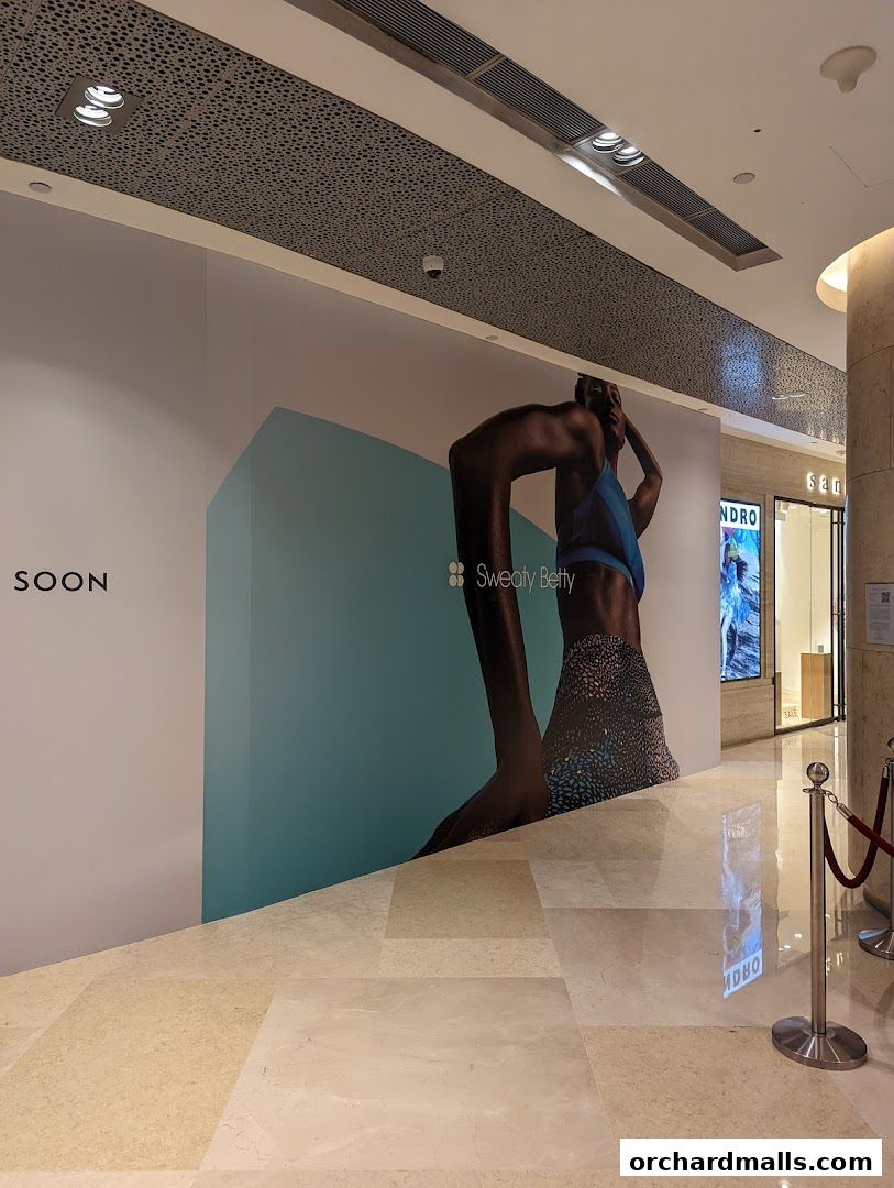 A large graphic advertisement for Sweaty Betty with a model in activewear.