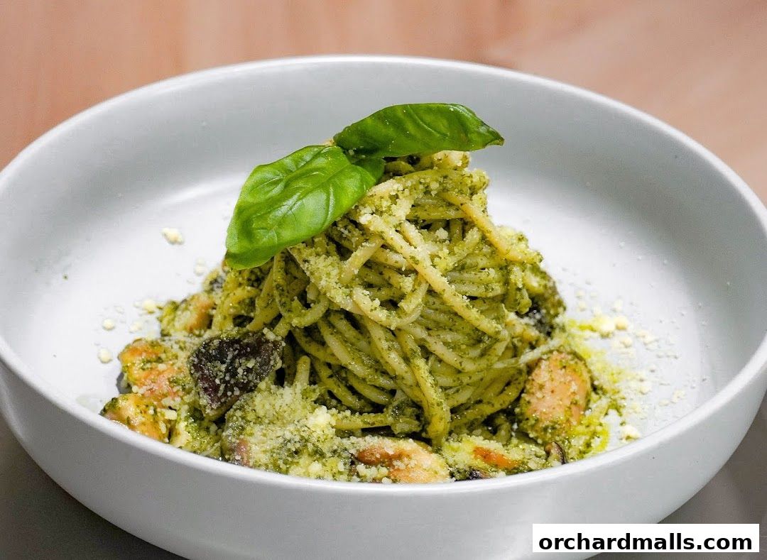 A close-up shot of a delicious pasta dish with pesto sauce and fresh basil.