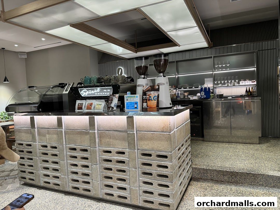 Interior of TAG Espresso shop with a modern counter, espresso machine, and coffee grinders.