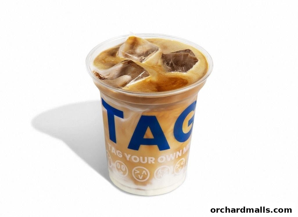 A refreshing iced coffee with milk and ice in a clear cup with the TAG logo.