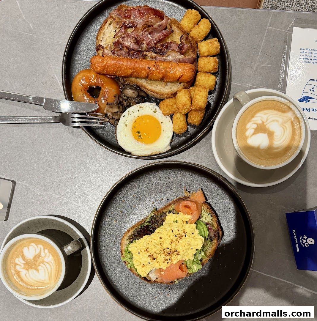 A delicious breakfast spread with coffee, featuring a full English breakfast and avocado toast with salmon.