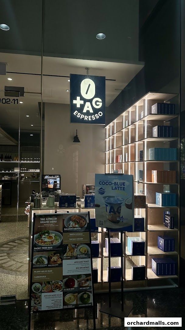 The exterior of TAG Espresso cafe with a menu board and products displayed.