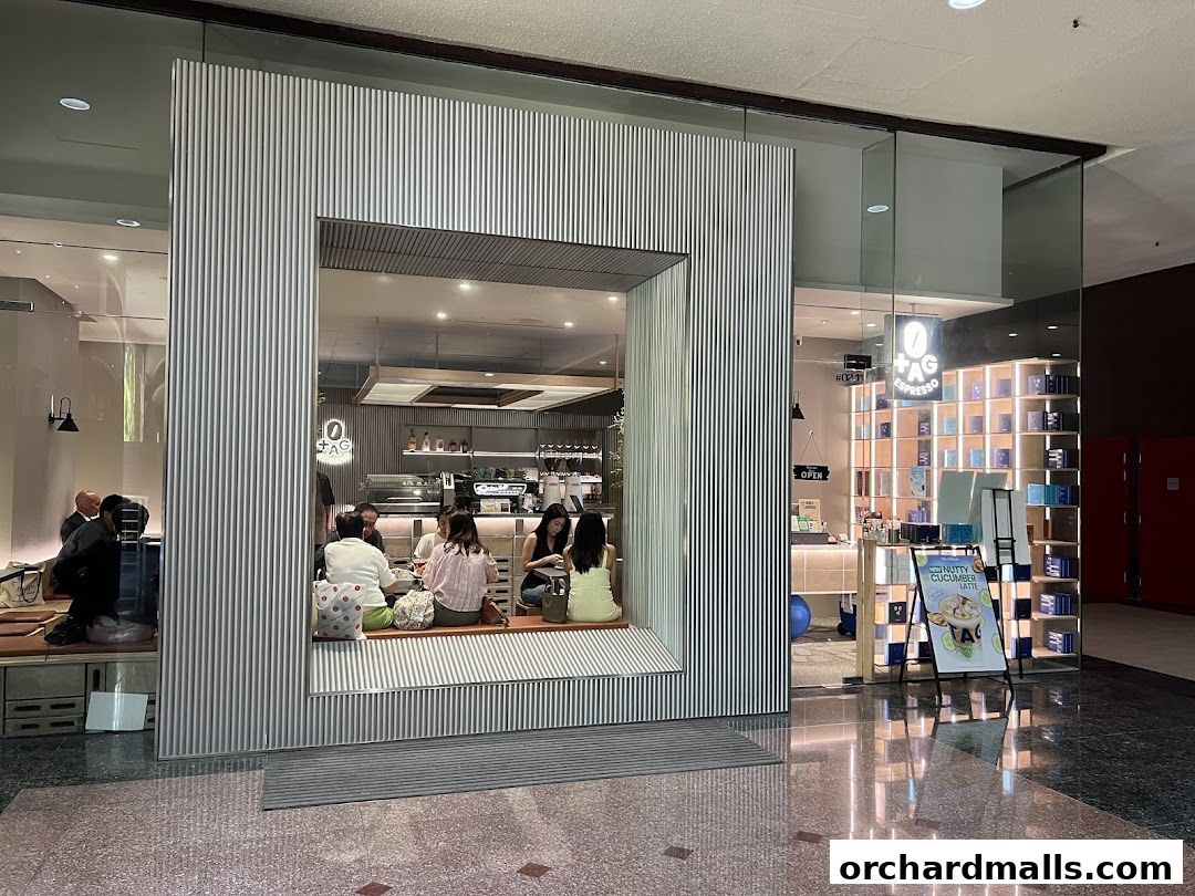 TAG Espresso shop with customers seated inside and a display of coffee products.