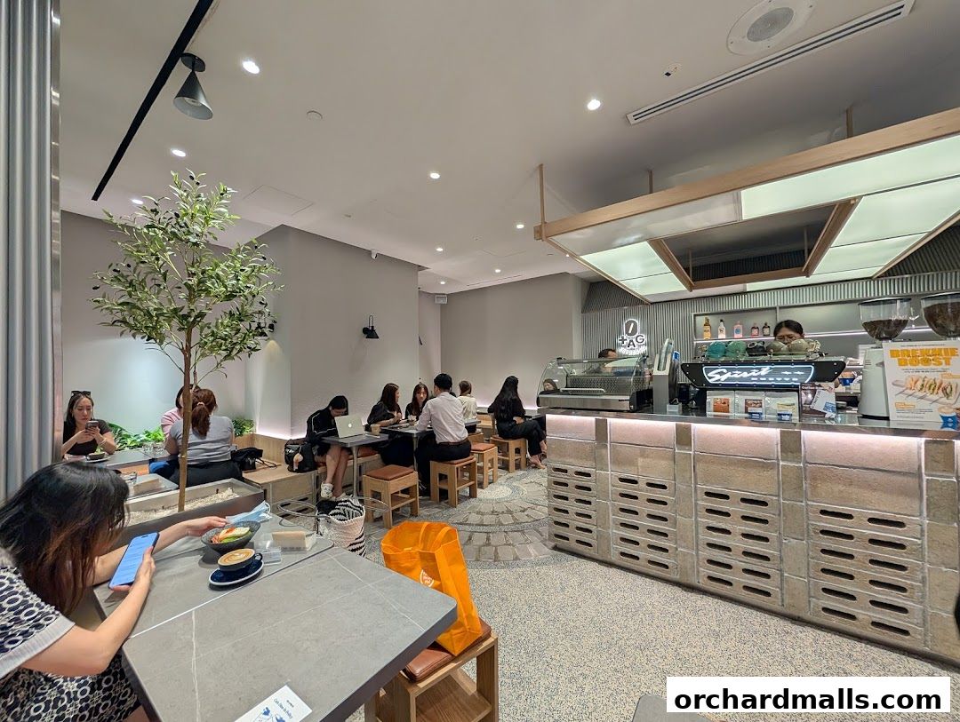 Interior of TAG Espresso cafe with customers seated and a barista behind the counter.