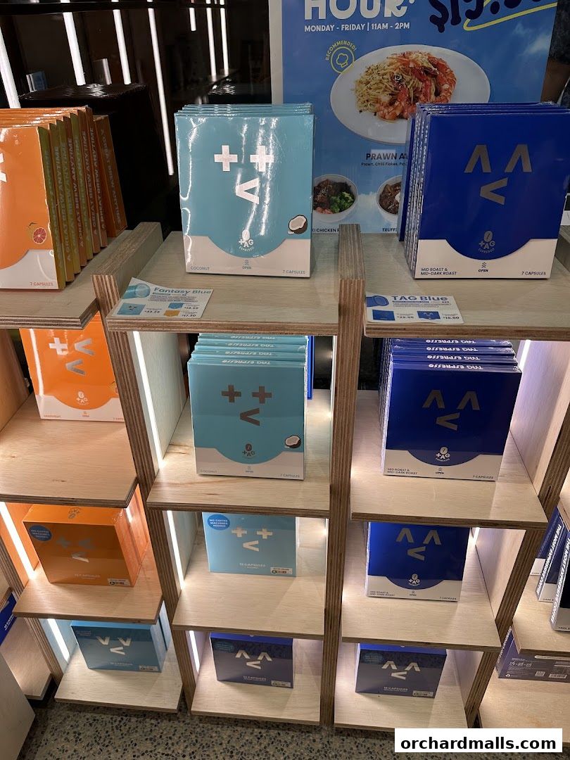 Shelves display various colorful boxes of TAG Espresso coffee capsules.