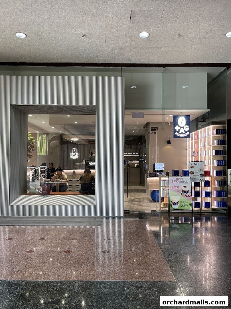 Exterior view of TAG Espresso cafe with customers inside and promotional signage.