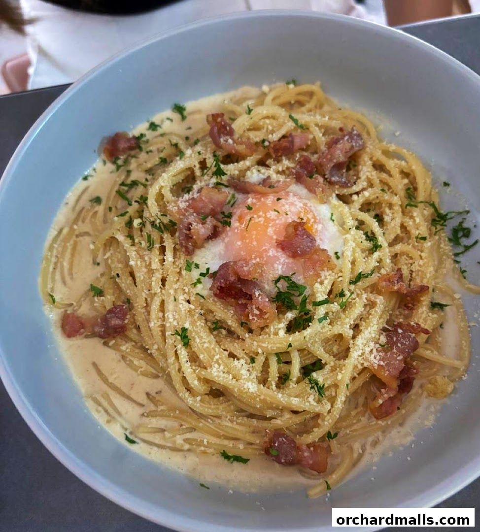 A close-up shot of a delicious spaghetti carbonara with bacon and a poached egg.
