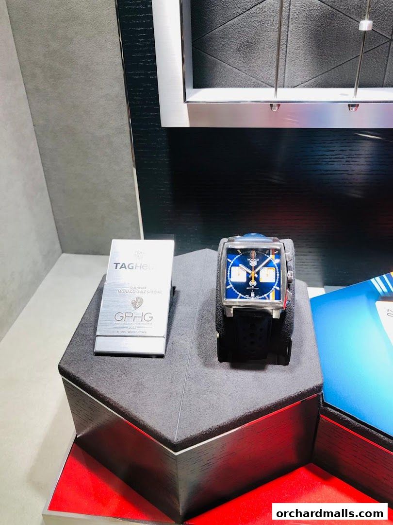 A TAG Heuer Monaco Gulf Special Edition watch displayed on a pedestal with its award.