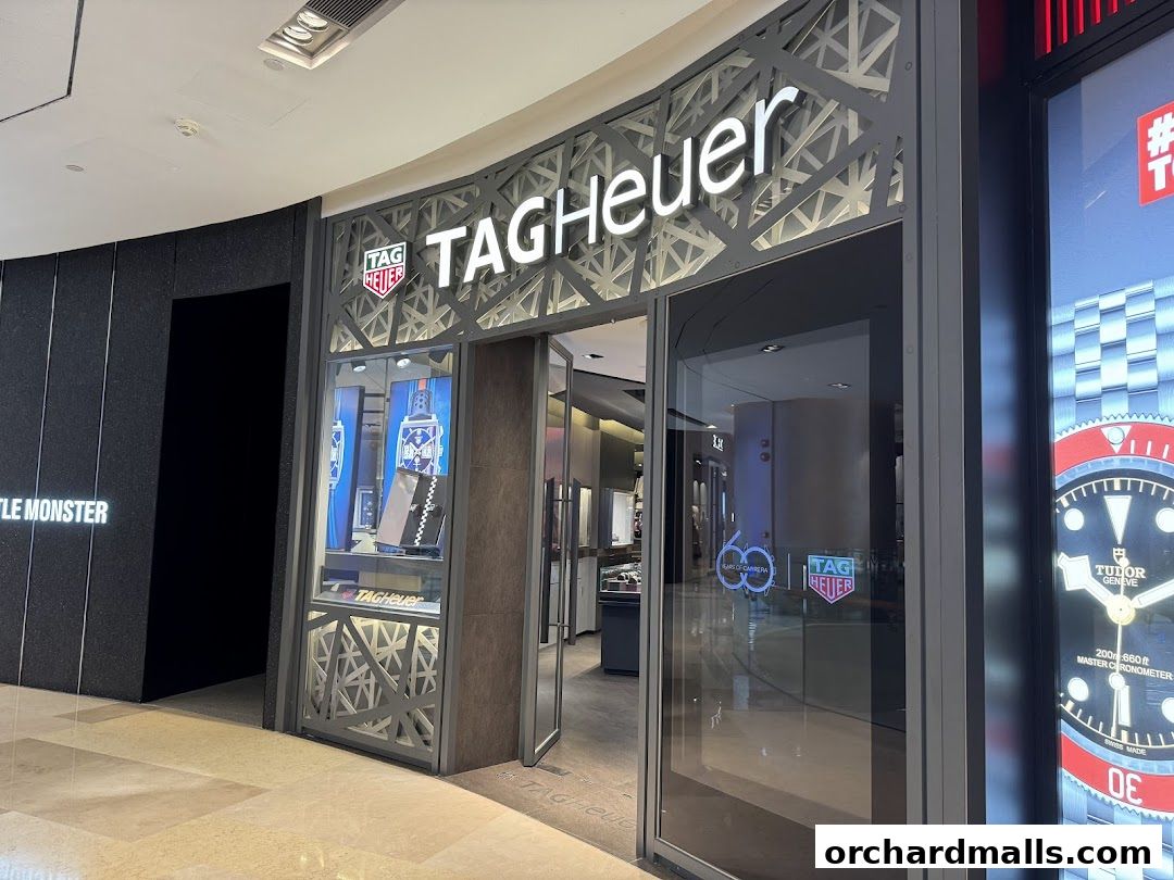 The modern storefront of a TAG Heuer watch shop with illuminated signage and display windows.