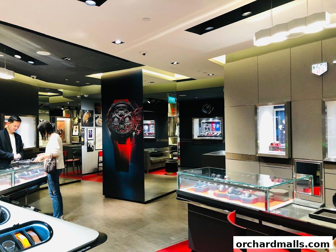 Customers browsing luxury watches in a modern TAG Heuer store with prominent displays.