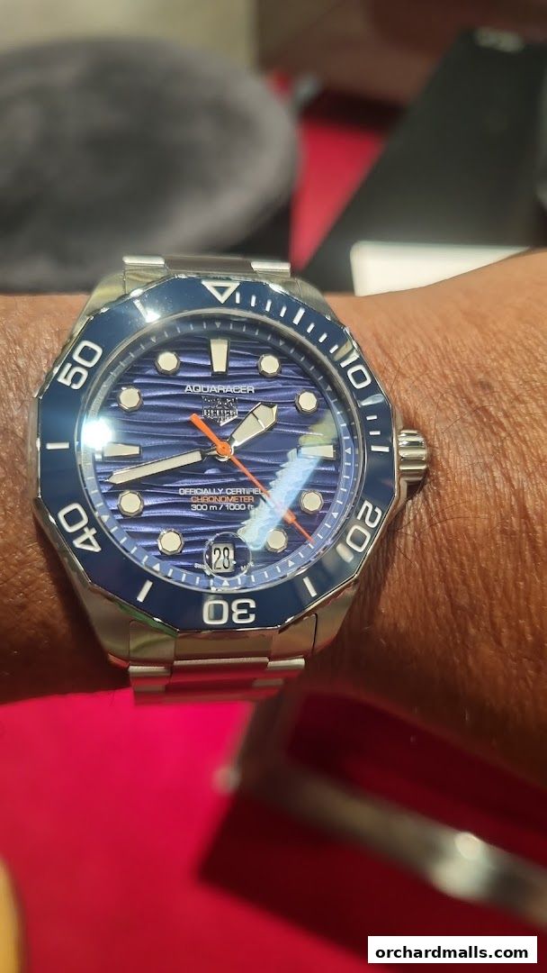 A close-up shot of a TAG Heuer Aquaracer watch with a blue dial on a wrist.
