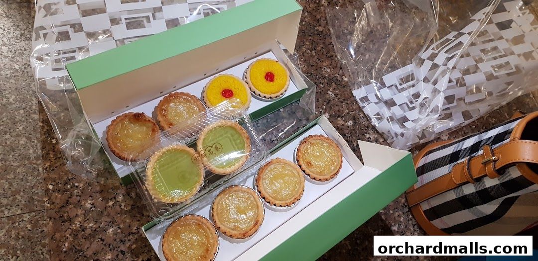 Assortment of delicious tarts and pastries in green boxes, ready for enjoyment.