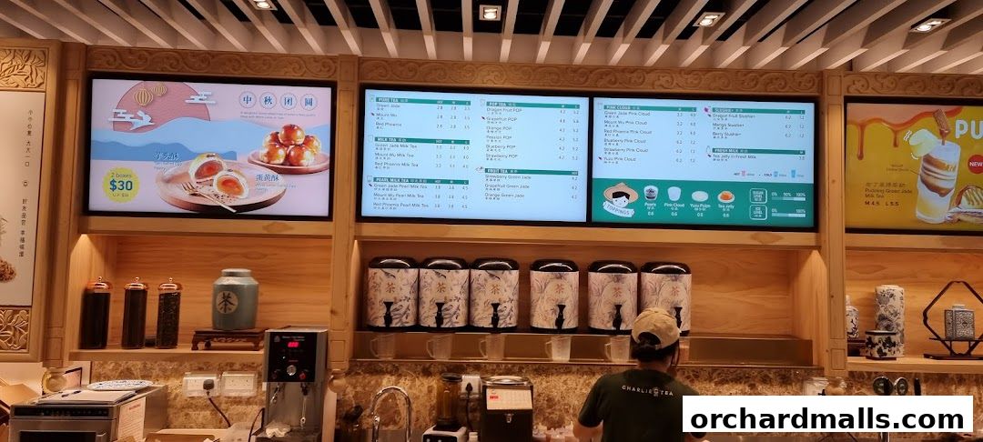 A digital menu board displaying various teas, milk teas, and fruit teas with prices.