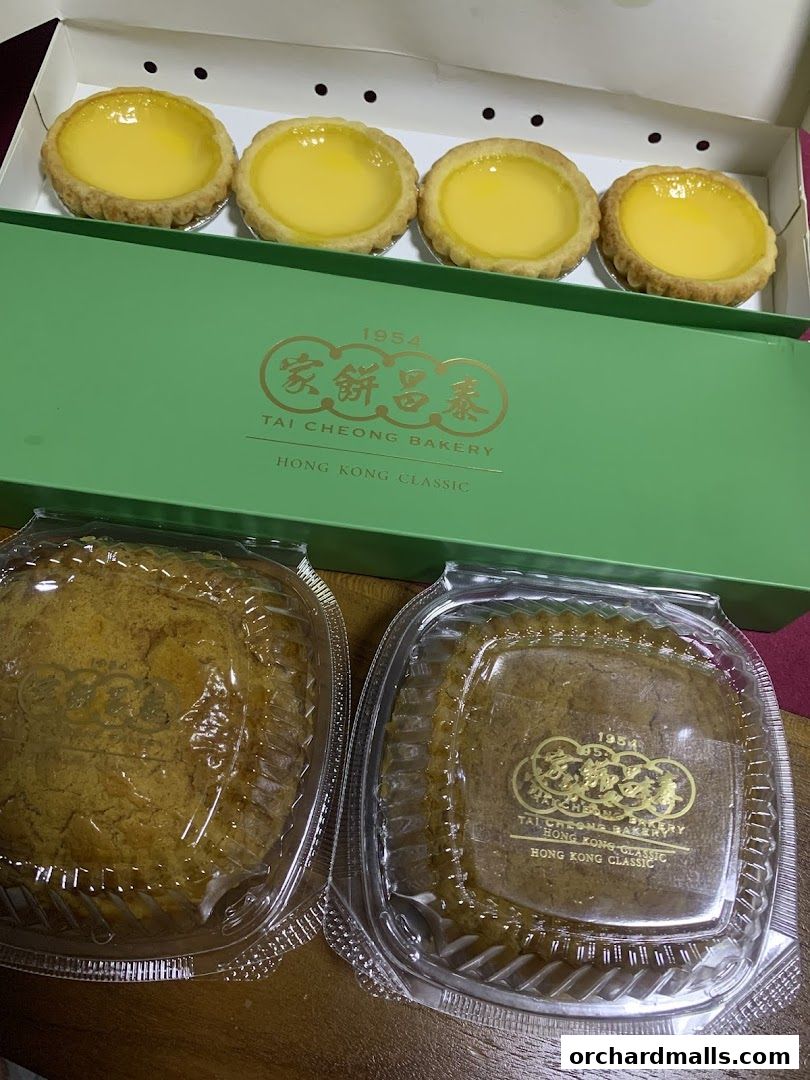 A box of egg tarts and two round cakes from Tai Cheong Bakery.